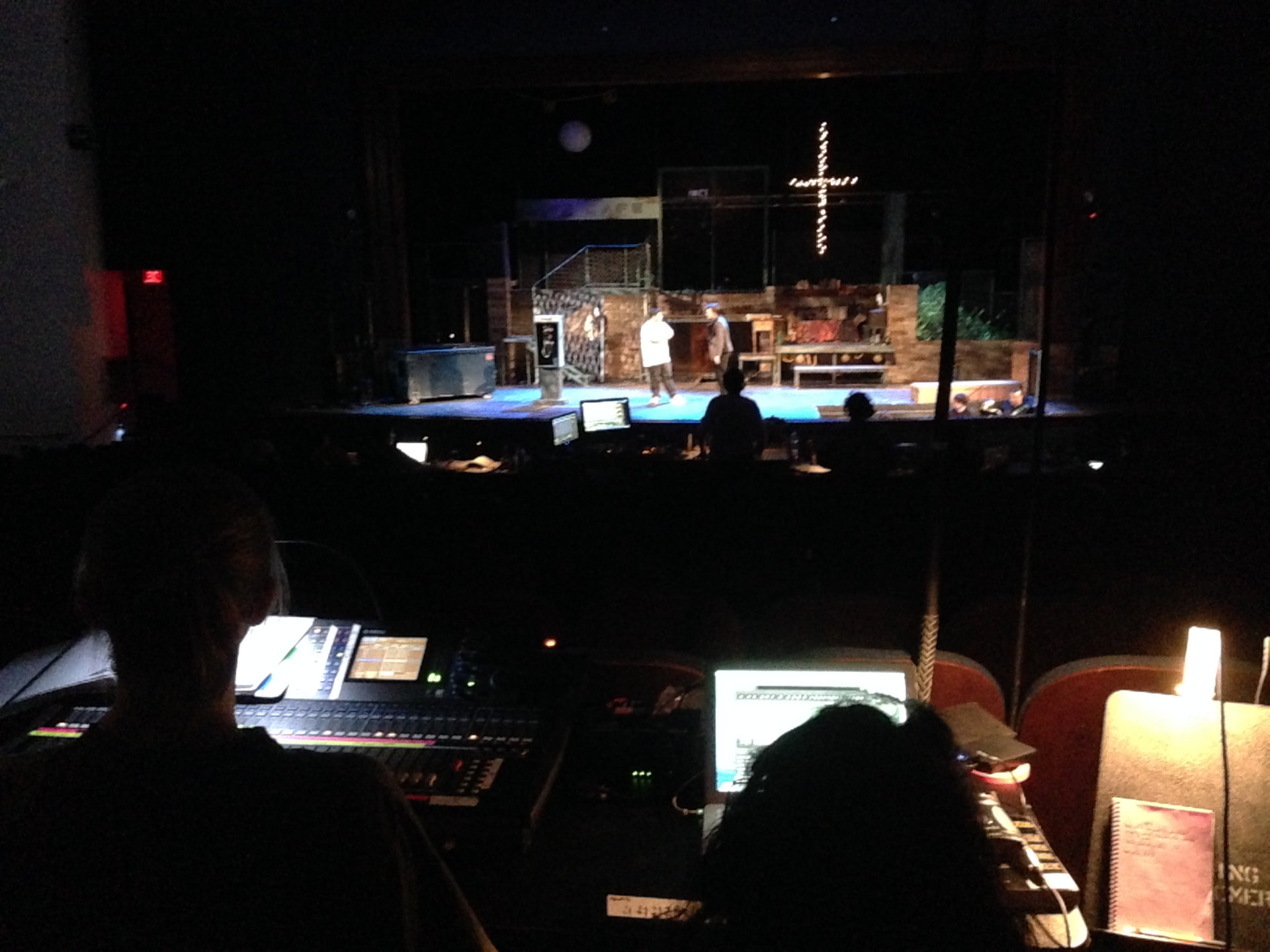 RENT at Montgomery College — view over the FOH console and QLab rig toward the lit stage during tech