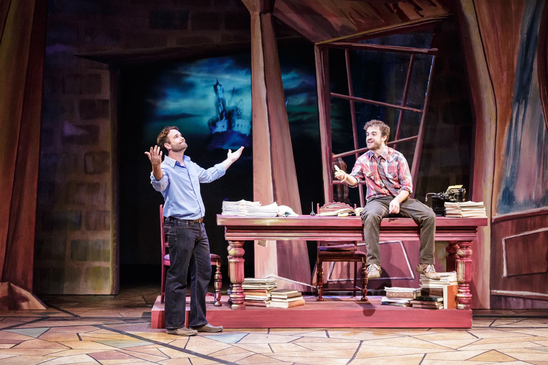 The Understudy — Harry and Jake trading lines at the writing desk with the castle drop behind