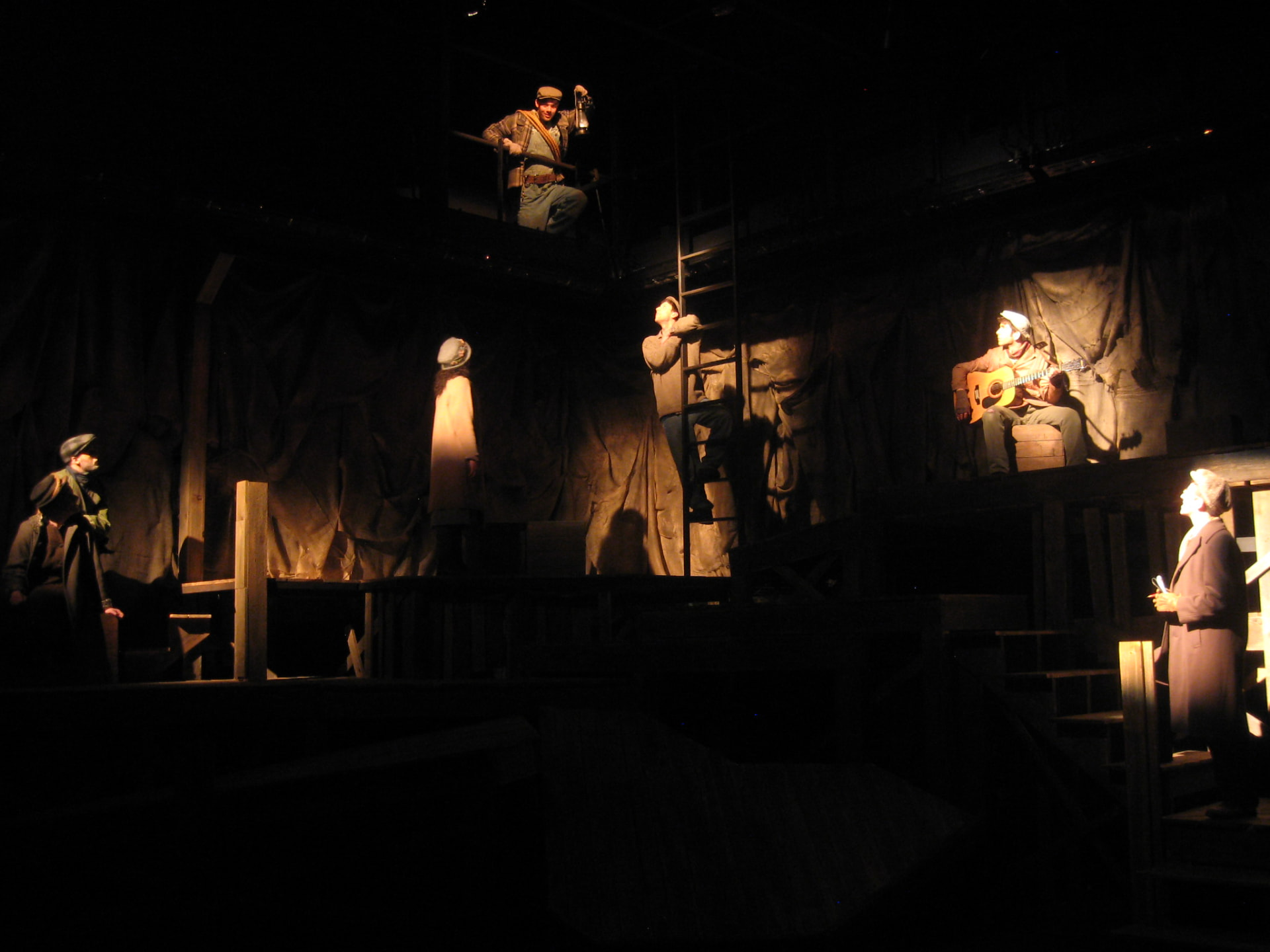 Floyd Collins — wide view of the multi-level cave set with the company in pools of lantern light