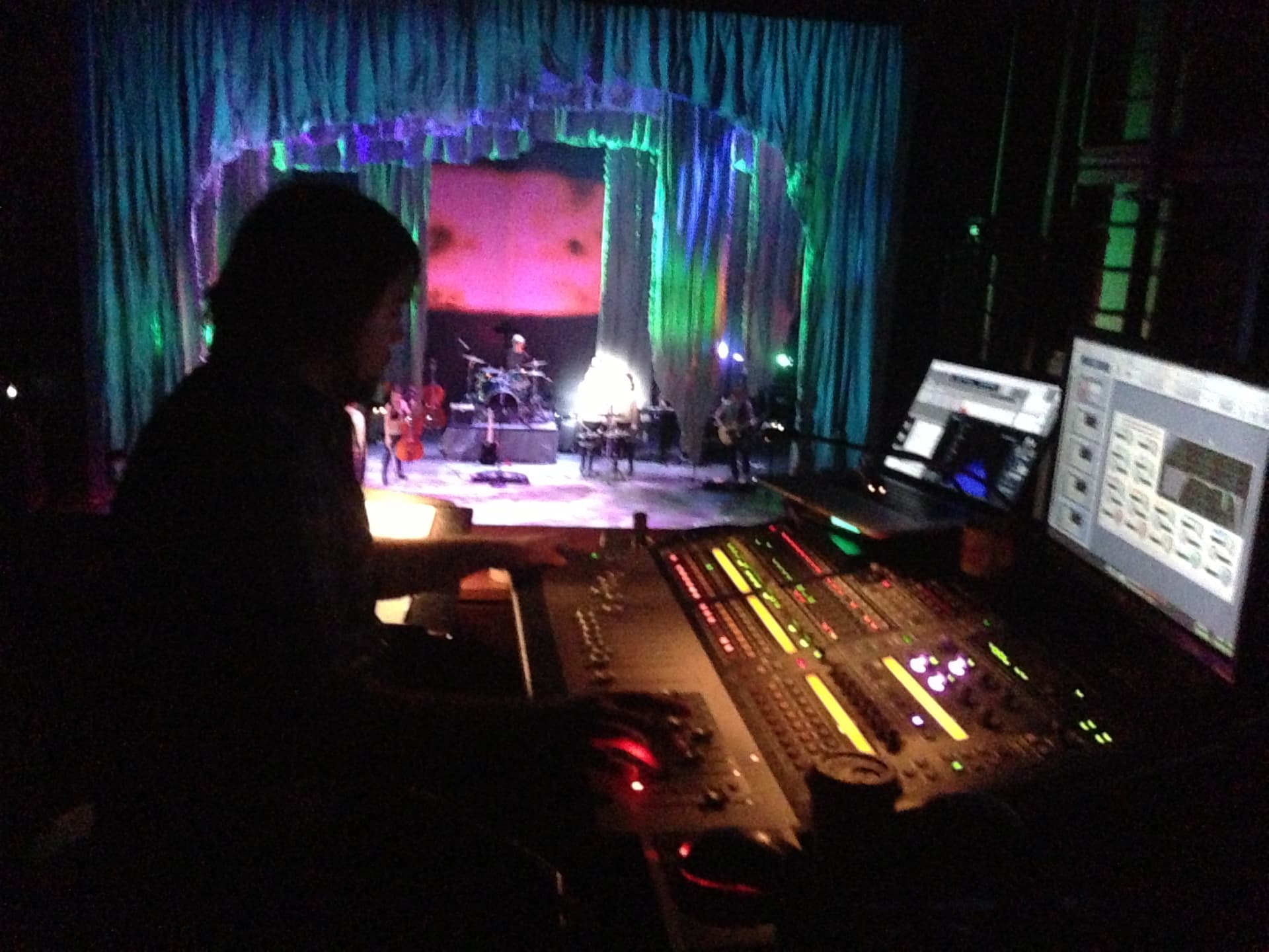 Medea — mix engineer at the FOH console mid-show, stage in view